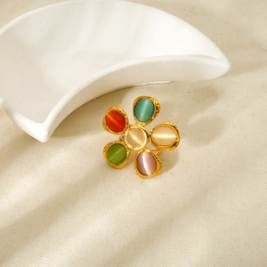 Primer plano de un anillo de flor con piedras ojo de gato de colores y textura dorada