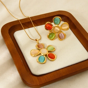 Vista de cerca del conjunto de joyas de flores doradas con piedras de ojo de gato