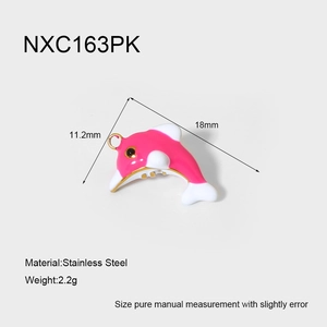 Macro detail of a 2.2g gold-plated dolphin pendant with pink and white enamel finish