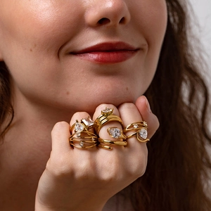 Detailed view of layered 18K gold plated rings with pear and rectangular shaped cubic zirconia