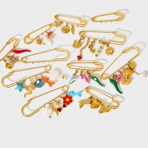 Detail of 18K gold-plated stainless steel brooches with colorful enamel pendants