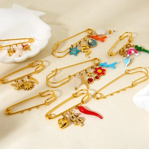Detail of 18K gold-plated pins with colorful enamel ocean and botanical charms