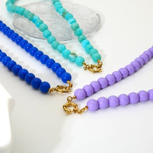 Dettaglio di perline colorate a cuore in acrilico blu e viola con chiusura a molla oro