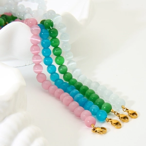 Detail of colorful cat-eye glass beaded necklaces with gold lobster clasp