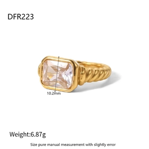 Detail van 18K gouden ring met rechthoekige zirkoon en gedraaide croissant-textuur