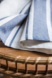 Close-up detail of blue and white striped cotton linen fabric texture on wooden table