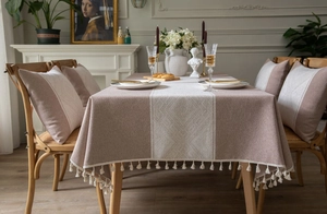 Détails de la nappe jacquard losanges rose poudré et blanc avec bordure à pompons