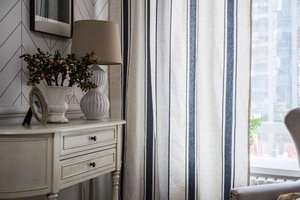 Detail view of navy blue striped cotton linen curtains showing textile texture in a cozy room