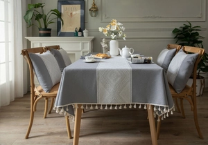 Détail de nappe en lin gris avec motifs de losanges blancs et bordure à franges élégante