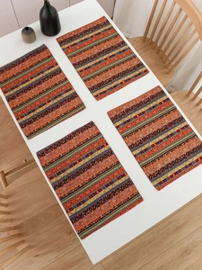 Set of four bohemian red striped cotton linen placemats displayed on a white table