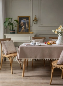 Detailed close-up of woven linen texture table cloth with white decorative fringe tassels