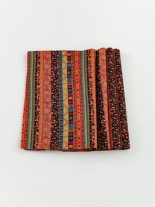 Detailed close-up of thick cotton linen placemat with red striped ethnic mosaic patterns