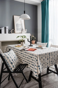 Close-up of blue wavy stripe print tablecloth and matching pillows in a modern setting