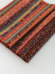 Detailed view of red striped heat-resistant placemat with ethnic geometric patterns