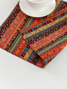 Detailed close-up of thick cotton linen placemat with red stripes and geometric patterns