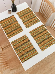 Close-up of four Bohemian striped place mats with geometric patterns on a white table