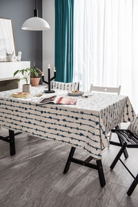 Close-up of blue wavy stripe linen tablecloth with matching cushion in a home setting