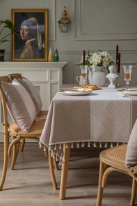 Détail du tissu jacquard à motifs losanges géométriques avec bordure à pompons blancs