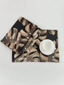 Detail of tropical monstera leaf placemat with watercolor pattern and stitched edges