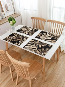 Detailed view of four rectangular placemats with tropical leaf patterns on a white table
