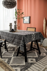 Detail of bohemian geometric print tablecloth on a dark wood table in a modern setting