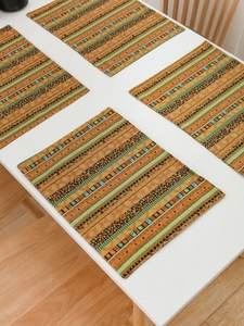 Detailed view of bohemian striped placemats in orange and green on a white table
