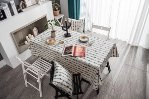 Detail of blue zigzag wavy print on linen-texture tablecloth with matching cushion cover