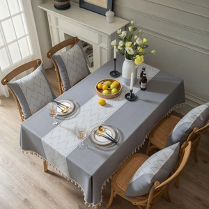 Grey linen-style tablecloth with geometric jacquard pattern and decorative tassels