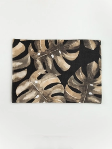 Flat lay of tropical monstera leaf print placemat on high-quality cotton linen fabric