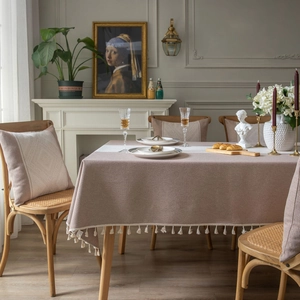 Nappe jacquard beige vintage avec pompons dans une salle à manger élégante