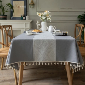 Nappe rectangulaire grise avec motifs jacquard à losanges blancs et pompons élégants
