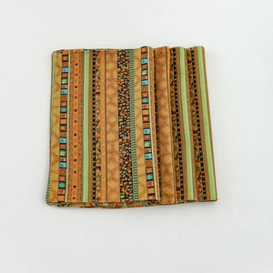 Striped pattern table mat in orange and gold with ethnic geometric printed fabric design