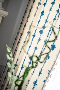 Gros plan sur le motif géo bleu sur rideaux de cuisine beiges tissés semi-occultants