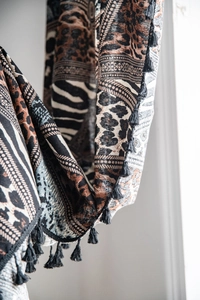Detail of bohemian leopard print curtain with geometric patterns and black fringe tassels