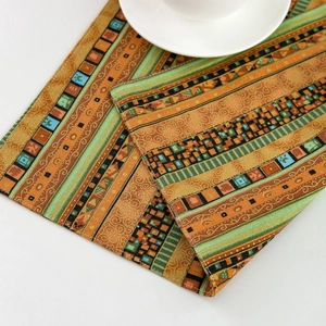 Bohemian striped table mat in orange and green with intricate geometric patterns