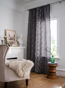 Detail of bohemian black geometric print curtain with stylish black tassel fringe trim