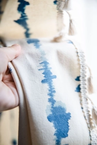 Détail du tissu en lin à rayures bleues avec pompons décoratifs et bordure frangée