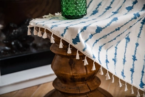 Détail du tissu à rayures bleues bohème avec finitions de pompons en coton ivoire