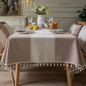 Grey American style jacquard tablecloth with wave pattern and tassels on a long dining table