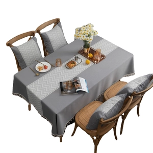 Grey linen-style tablecloth with white wavy jacquard pattern and matching cushions