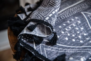 Close-up of bohemian geometric print fabric with handmade black tassel fringe detail
