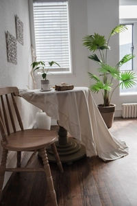 Detailed view of cream ruffled lotus leaf edge on a washed cotton round tablecloth
