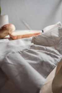 Close-up of beige ruffled tablecloth with natural cotton texture and lifestyle props