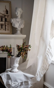 Detailed texture of white linen curtain with ruffled edges in a French vintage interior