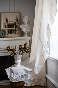Detailed close-up of cream cotton linen curtain with vintage ruffle edge design