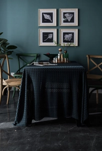 Close-up of dark green rectangular hollow geometric lace tablecloth texture and lace edge