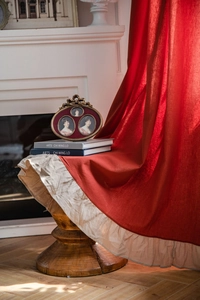 Dettaglio della trama in lino della tenda con tessuto rosso scuro e bordo con volant beige