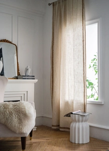 Détail de rideau en lin et coton semi-transparent avec une élégante broderie dorée