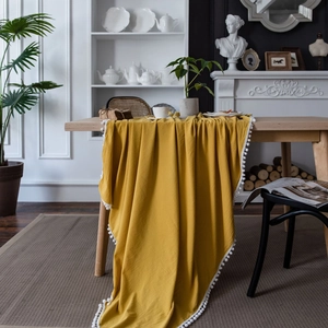 Minimalist ginger yellow wash cotton tablecloth with white pom-pom fringe for home decor