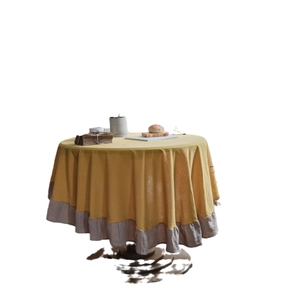 Minimalist ginger yellow round tablecloth with grey ruffle hem made of washed cotton